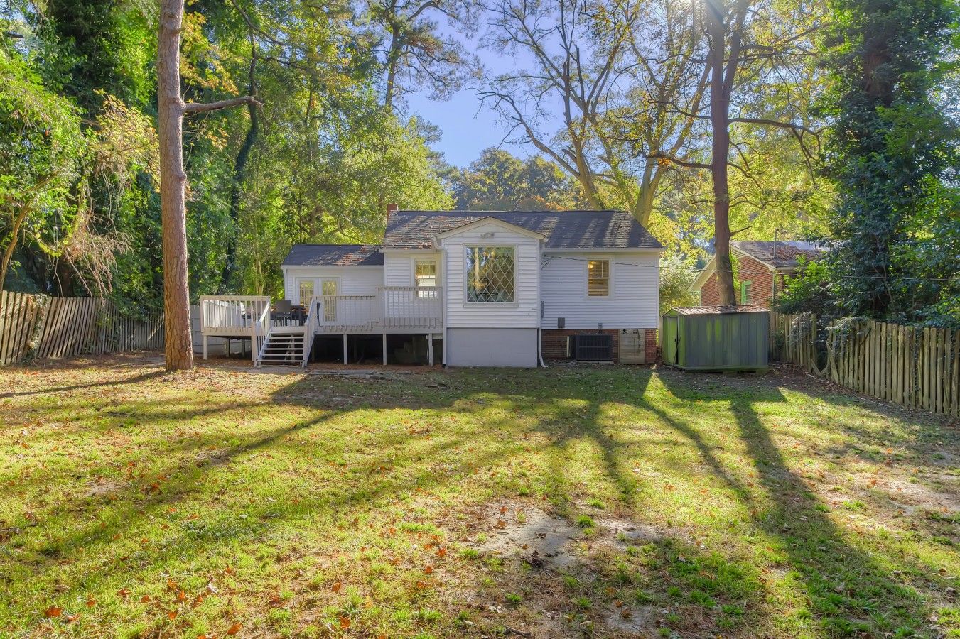 A two-story house with a deck and a fenced yard.