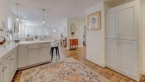 A spacious kitchen with white cabinetry, a central island, and pendant lighting.