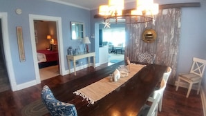 Un comedor con una mesa de madera oscura, sillas estampadas azules y una araña.