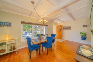 A dining area with a wooden table, blue chairs, and a chandelier.