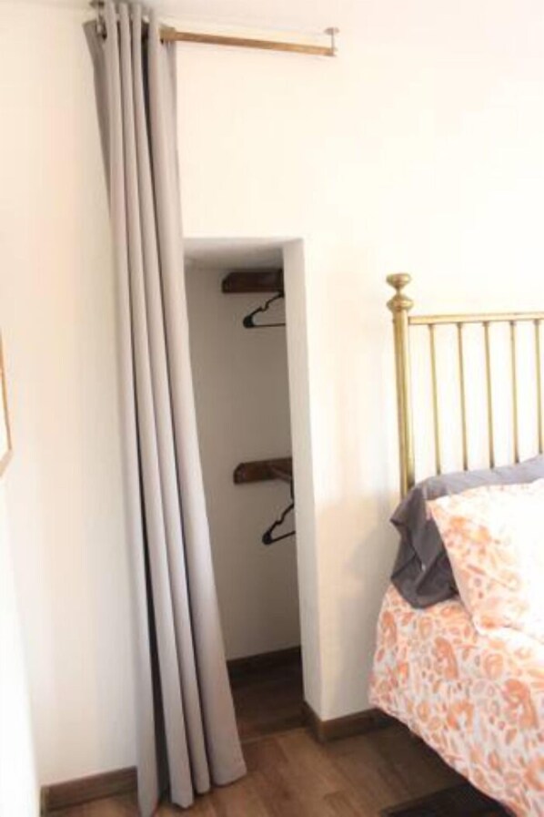 A bedroom with a bed, a wardrobe, and a curtain.