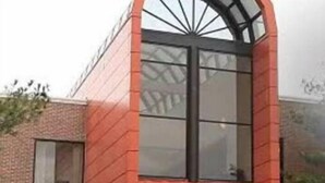 Un edificio moderno con fachada de ladrillo rojo y ventanas amplias.