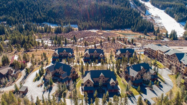 A cluster of chalet-style buildings with steep roofs, surrounded by a forested area and a ski slope in the background. - Private Garage/Walk to the Gondola in 2 Minutes/Pool and Hot Tub/Fitness Room (Keystone)