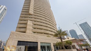 Un edificio moderno e slanciato con una facciata curvilinea, ampie finestre e un ingresso ben visibile con decorazioni.