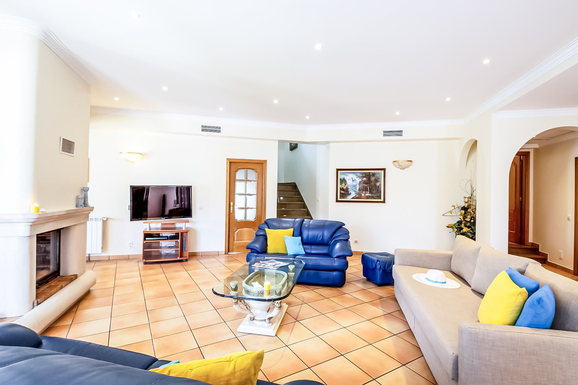 A living room with a fireplace, a television, a sofa, and a coffee table.