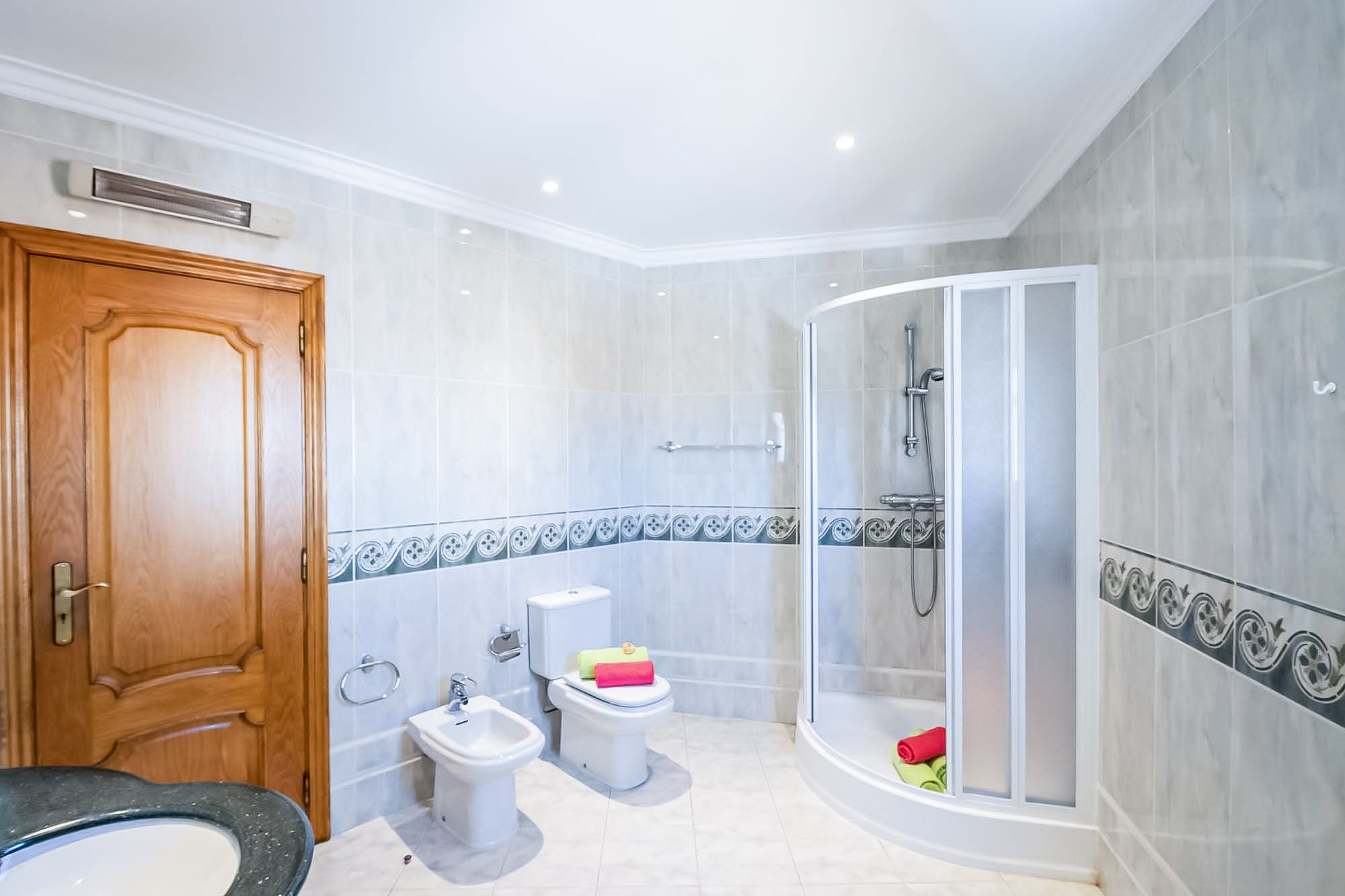 Ein Badezimmer mit Dusche, Toilette, Bidet und Waschbecken.