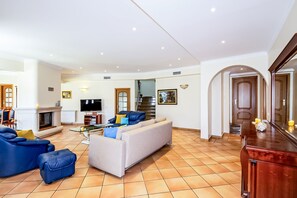 A spacious living room with a fireplace, a sofa set, and a television. - Villa w/ heatable pool & BBQ, Albufeira (Albufeira)