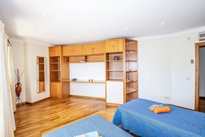 A bedroom with a wooden wardrobe, a bed with blue bedding, and a small table with a vase. - Villa w/ heatable pool & BBQ, Albufeira (Albufeira)