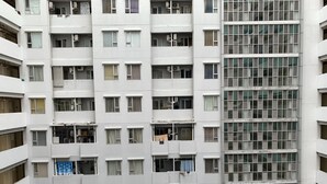 A multi-story residential building with balconies, air conditioning units, and a grid-like window pattern on one side. - Comfort Studio at Menteng Square Apartment (Jakarta)