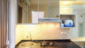 A kitchen with a gas stove, sink, and a microwave.