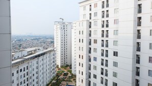 Un immeuble résidentiel de grande hauteur doté de nombreux balcons, d’une piscine sur le toit et offrant une vue sur le paysage urbain.