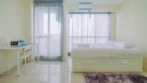 Um quarto com cama, escrivaninha e cadeira.
