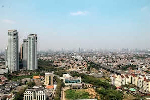A cityscape with high-rise buildings, a mix of residential and commercial structures, and a highway. - Best Location 1BR The Mansion at Kemang Apartment (Jakarta)