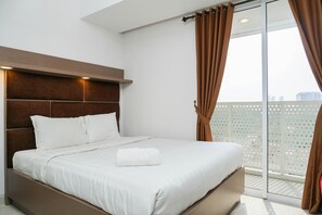 A modern hotel room with a large bed, a wooden headboard, and a view of the city through a large window with curtains.
