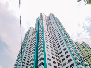 A high-rise building with multiple floors, featuring balconies and windows. - Best Homey Elegant Studio Room at Amethyst Apartment (Jakarta)