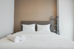 A neatly made bed with white linens and pillows, a grey headboard, and a small metal shelf unit beside it. - Stunning and Good Location Studio at Menteng Park Apartment (Jakarta)