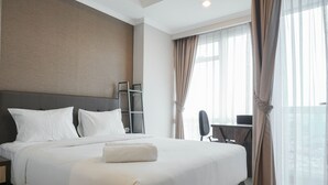 Una camera d'albergo con un letto grande, una scrivania e una sedia.