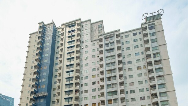 A high-rise residential building with multiple balconies and a blue accent wall. - Strategic 2BR at Sudirman Park Apartment (Jakarta)