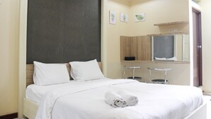 A hotel room with a bed, two chairs, a small table, a mirror, and artwork on the wall. - Minimalist Studio Gateway Ahmad Yani (Bandung)