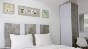 A hotel room with a bed, a chair, and a wardrobe. - Modern Look Studio Apartment at Grand Asia Afrika (Bandung)