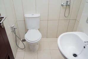 Une salle de bain avec des toilettes, une douche et un lavabo.