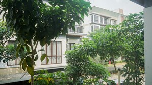 A residential building with a balcony, surrounded by lush greenery. - Comfortable and Best Choice 1BR at Asatti Apartment (Pagedangan)