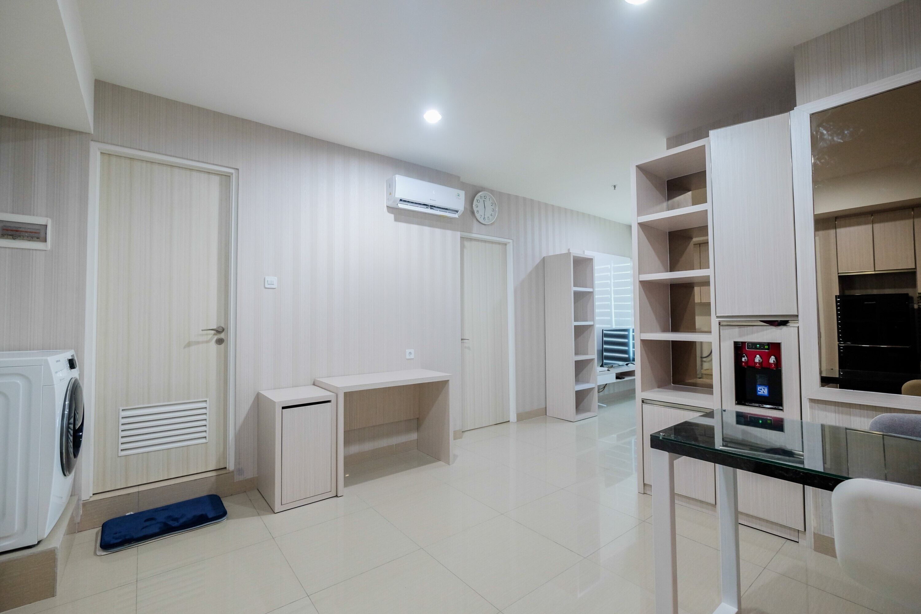 A modern kitchen with built-in appliances, a dining area, and a small workspace.