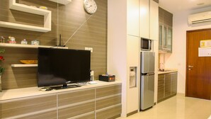 Eine moderne Küche mit Flachbildfernseher, Mikrowelle, Kühlschrank und eingebauten Schränken.