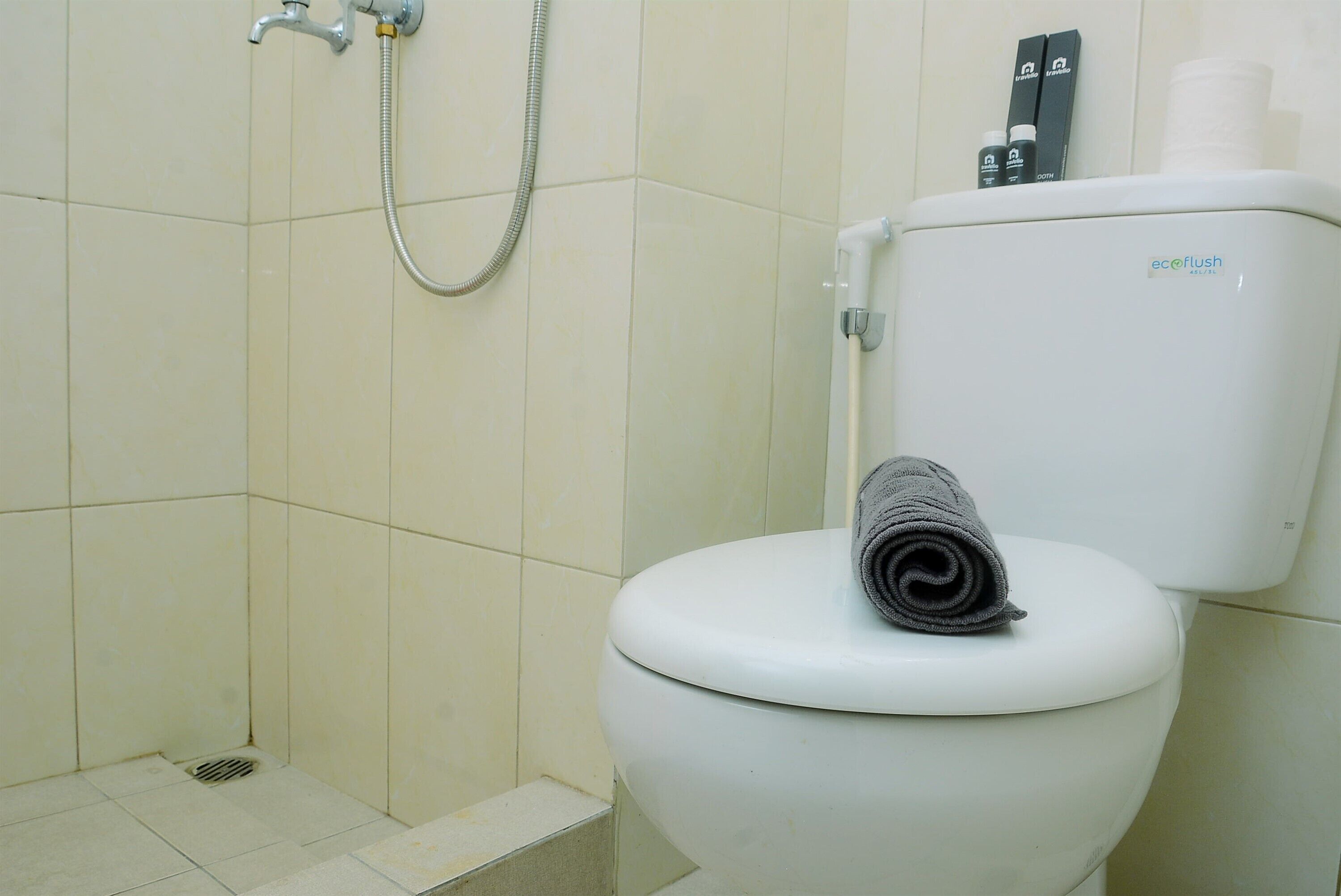 Ein Badezimmer mit Toilette, Dusche und Toilettenpapierhalter.