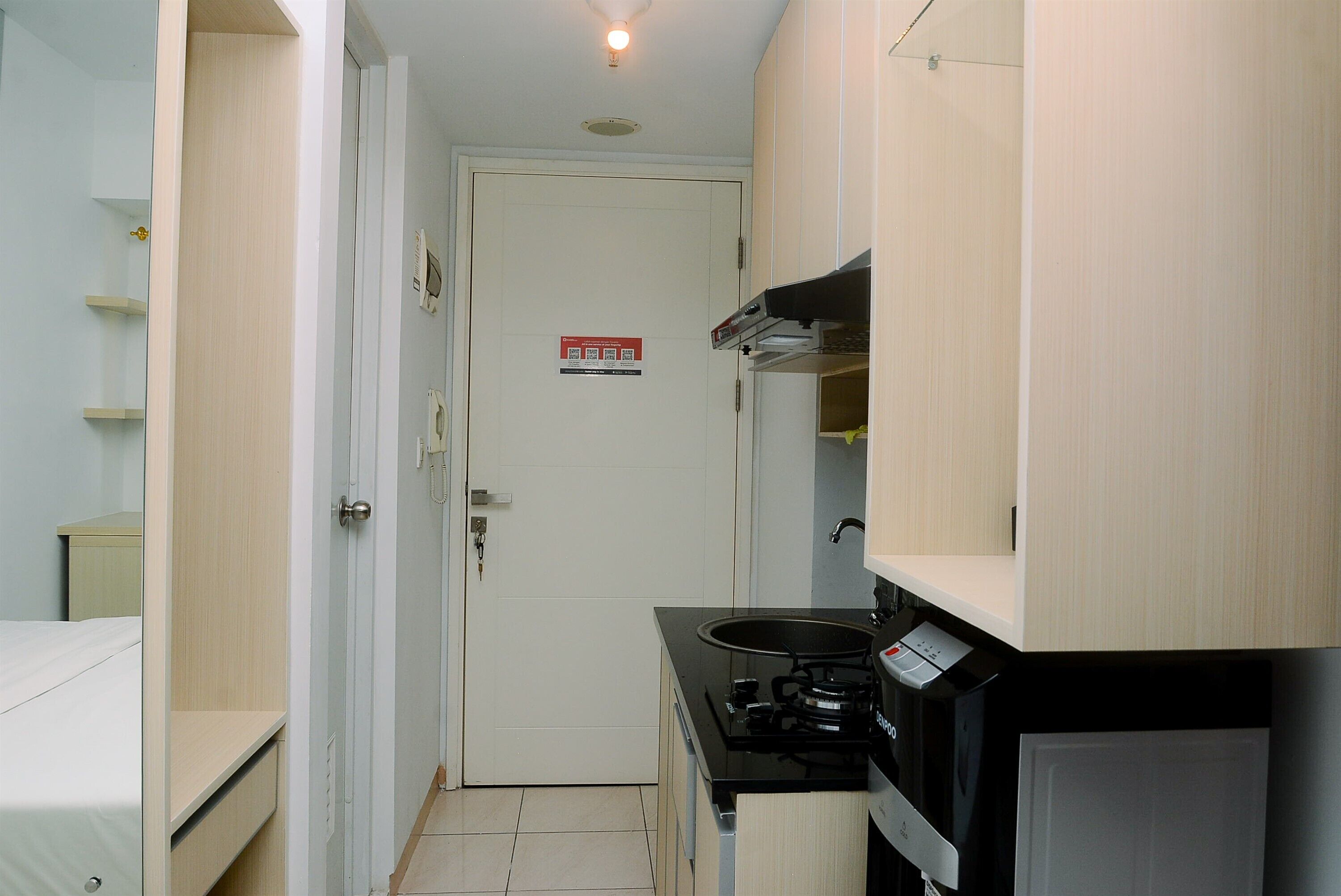 A compact kitchen with a stove, microwave, and cabinets.