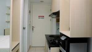 Una cocina compacta con estufa, microondas y alacenas.