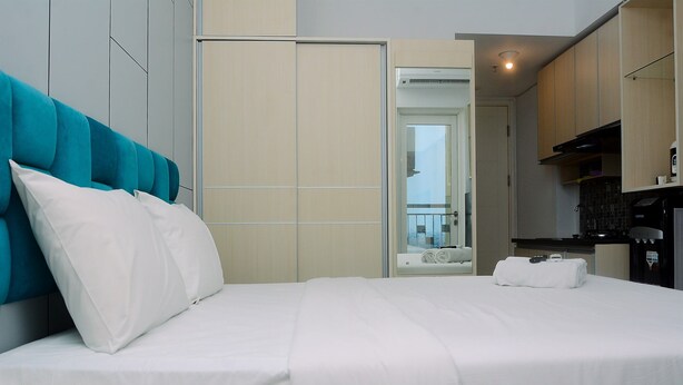 Una habitación de hotel con cama, armario y kitchenette.