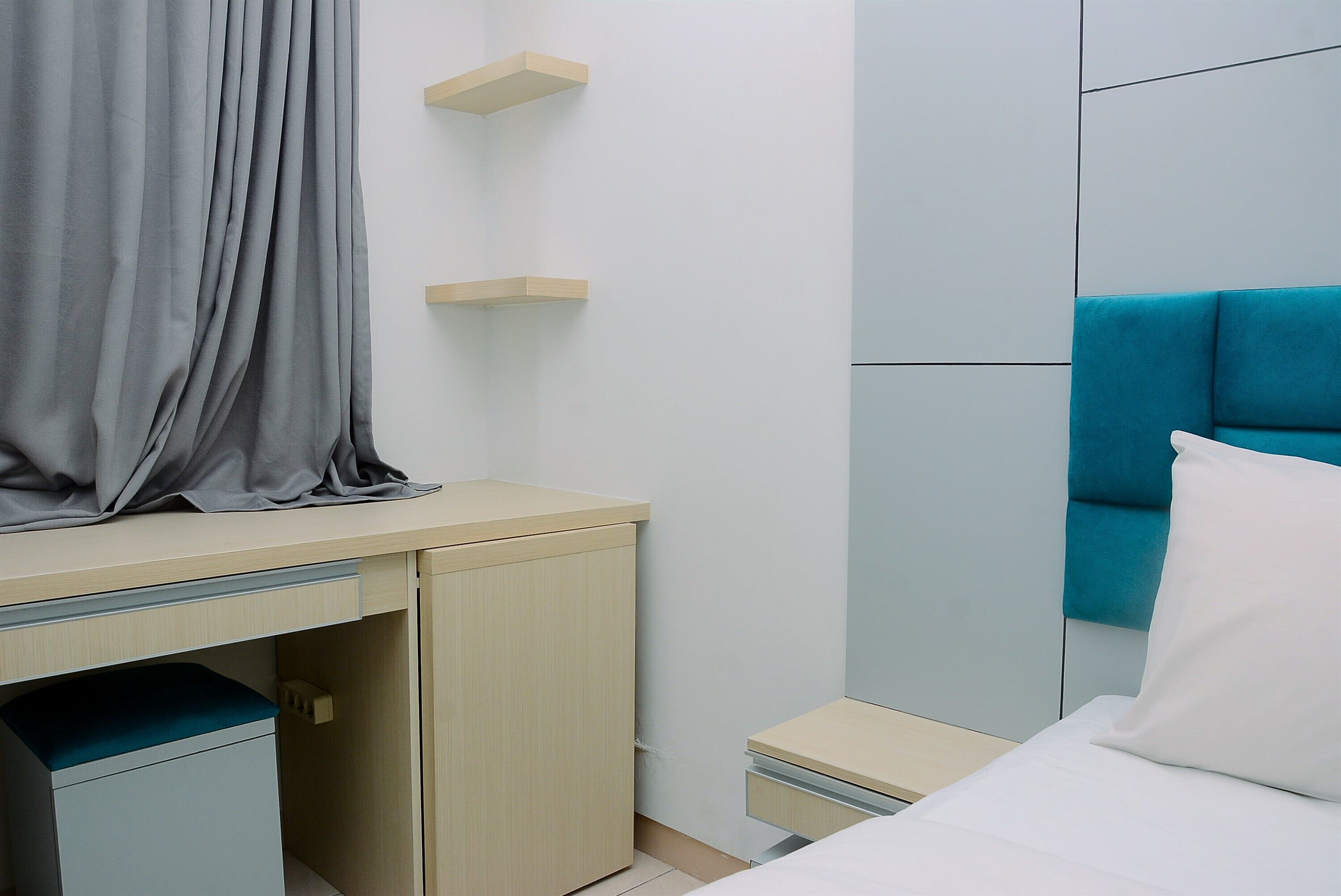 A bedroom with a bed, a desk, and a chair.