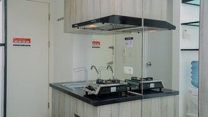 Une cuisine moderne dotée d’une hotte noire, d’un évier en acier inoxydable et d’un distributeur d’eau.