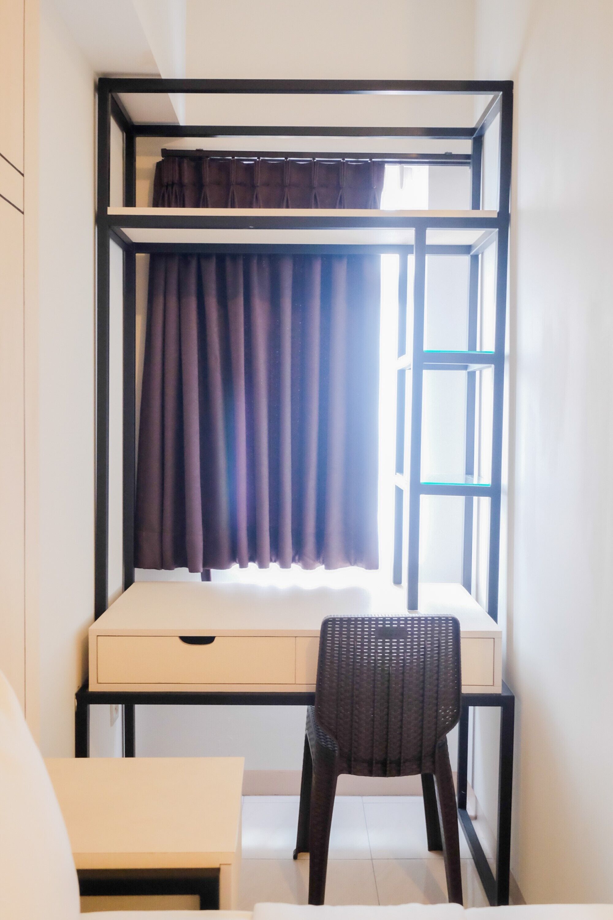 A compact room with a bunk bed, a desk, and a chair.