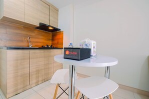 Une cuisine moderne avec des meubles en bois, un évier et une table équipée d’un distributeur d’eau et d’une boîte étiquetée « Travelio ».