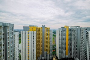 Un edificio residencial de gran altura, con varios balcones y vistas del paisaje urbano circundante.