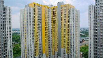 A high-rise residential building with multiple balconies and a river view.