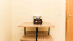 Ett litet träbord med en svart låda ovanpå, märkt med texten ”travelio”, en bänk och en trädörr.