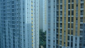 Un edificio residencial alto con varios balcones y fachada uniforme.