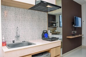 Room | Private kitchen | Fridge, stovetop, cookware/dishes/utensils - Comfy Studio Room at Evenciio Margonda Apartment (Depok)
