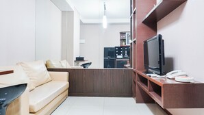 A modern living room with a sofa, a television, and a wooden entertainment unit.