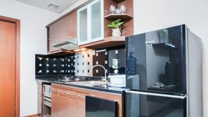 A modern kitchen with a built-in oven, a refrigerator, and a sink.