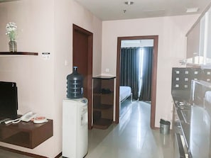 Enjoy a comfortable stay in this well-equipped room featuring a kitchenette with a refrigerator, microwave, and water dispenser.