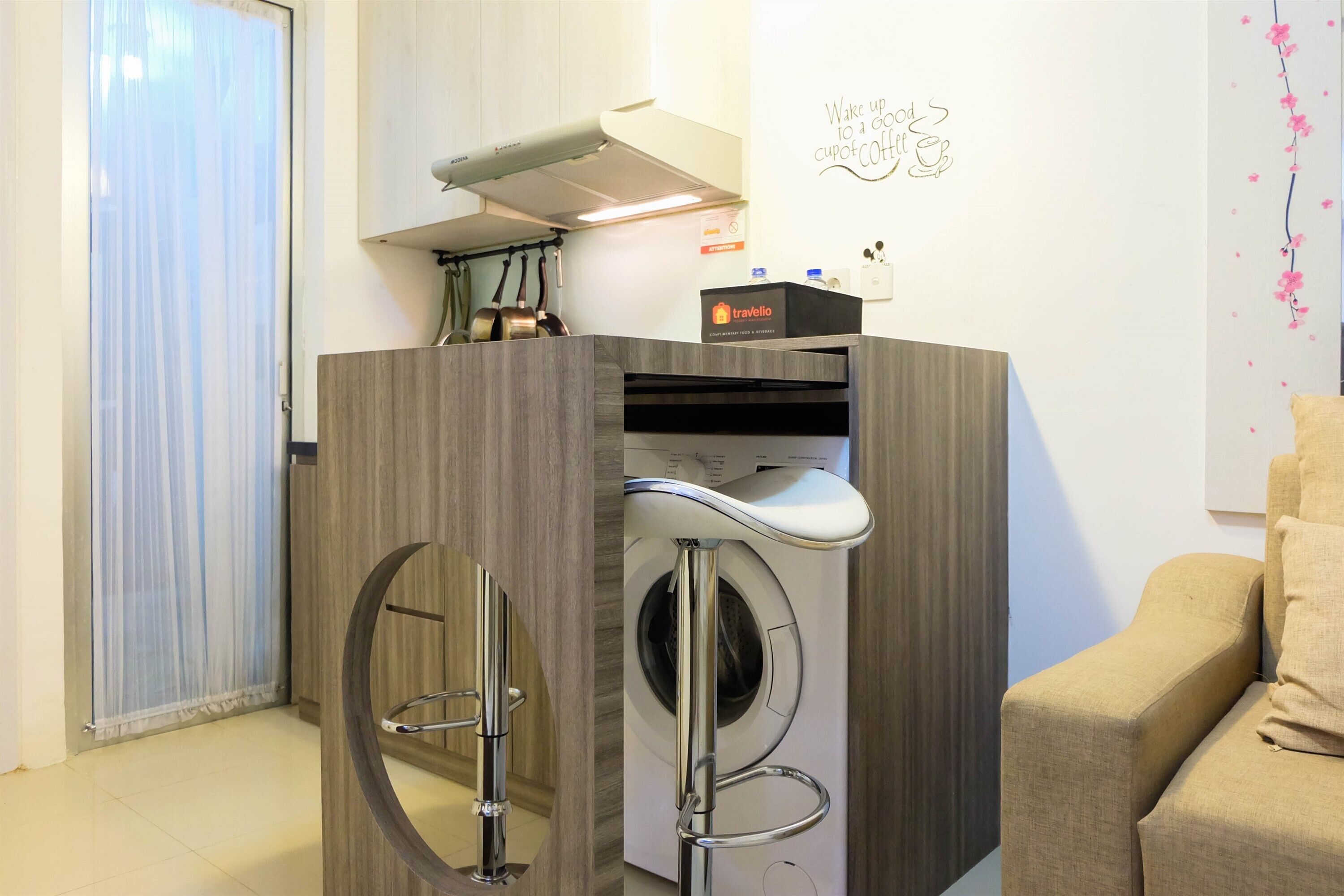 A compact laundry area with a washing machine and dryer, a wooden cabinet, and a towel rack.
