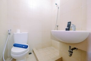 A bathroom with a toilet, a shower, and a sink. - Simple Furnished Studio Apartment at Maple Park (Jakarta)