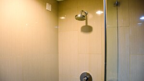 A modern bathroom with a glass shower enclosure, a wall-mounted showerhead, and a visible control knob. - Chic and Cozy 1BR Apartment at H Residence near MT Haryono (Jakarta)