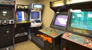 Eine Reihe von Spielautomaten mit verschiedenen Spielen, darunter Rennspiele und Schießspiele.