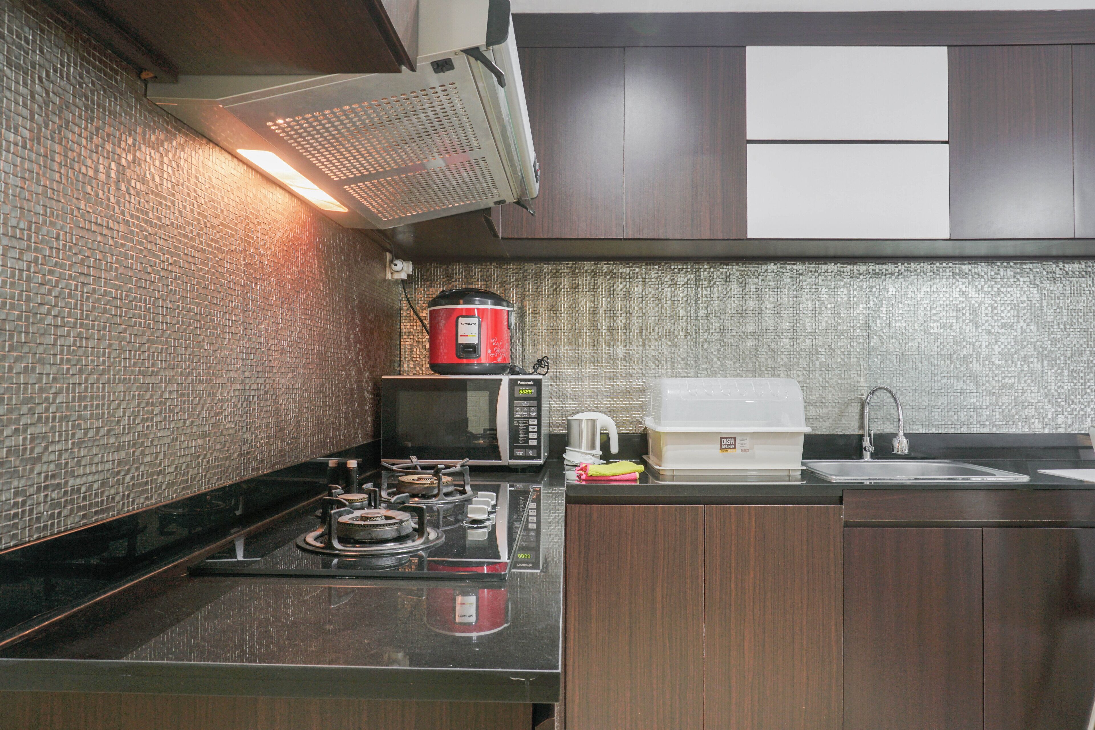 A kitchen with a microwave, stove, and sink.