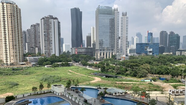 A high-rise building complex with multiple swimming pools and a landscaped area. - Best Location 2BR at The Wave Kuningan Apartment (Jakarta)